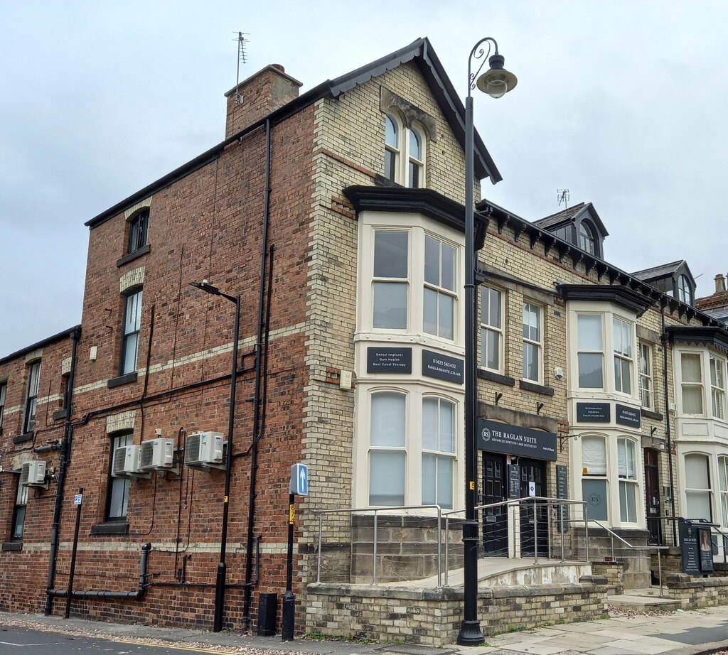 Raglan Chambers on Raglan Street, Harrogate: a three-storey stone-and-brick Victorian building with bay windows, dormer roof and a wrought-iron lamp post on the corner of Princes Square.